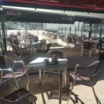 Terraza exterior de la Vinoteca Belarmino con mesas y sillas listas para los clientes.