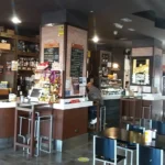 Interior de la Vinoteca Belarmino con barra, mesas y decoración acogedora.