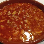 Plato de callos caseros servidos en cazuela de barro.