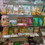 Estantería con productos ecológicos y saludables como harinas, cereales, snacks y superalimentos en una tienda natural.