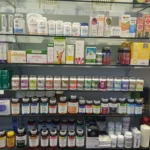 Estantería con suplementos alimenticios, vitaminas y productos naturales organizados por filas en una tienda.