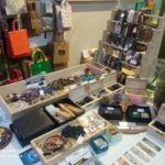 Mesa con pulseras, piedras naturales, joyas y accesorios en una tienda ecológica.