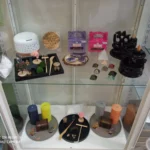 Vitrina con velas, inciensos, pirámides energéticas y objetos decorativos en una tienda ecológica.