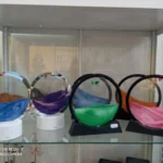 Lamparas de arena decorativos circulares con arena de colores en una vitrina de tienda.