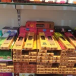 Estantería con cajas de inciensos naturales de diferentes aromas como lavanda, canela, vainilla, palo santo y ruda en una tienda ecológica.