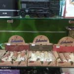 Estantería con cajas de sahumerios naturales “Sahumitos” en diferentes aromas como canela y anís, ruda y rosas, en una tienda ecológica.