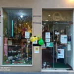 Fachada de la tienda Oasis con escaparate y puerta de cristal decorada con globos.