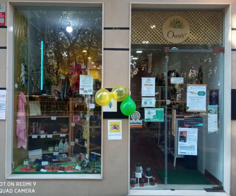 Fachada de la tienda Oasis con escaparate y puerta de cristal decorada con globos.
