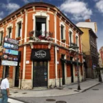 Fachada de edificio histórico en esquina con el local “L’Antigua” en una calle peatonal de Langreo.